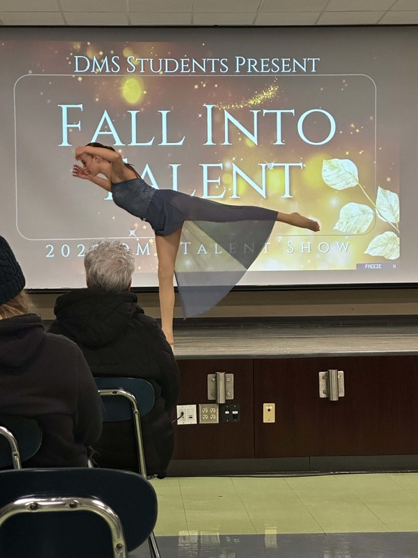 Students stand on stage at talent show