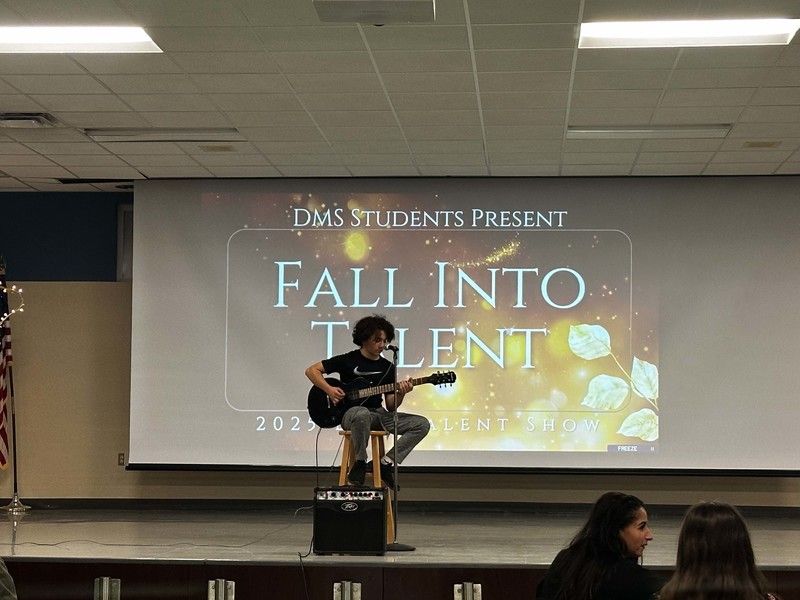 Students stand on stage at talent show