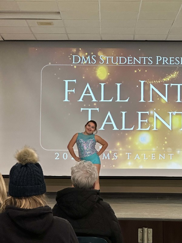 Students stand on stage at talent show