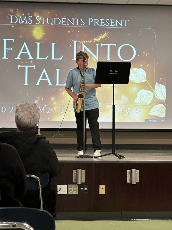 Students stand on stage at talent show