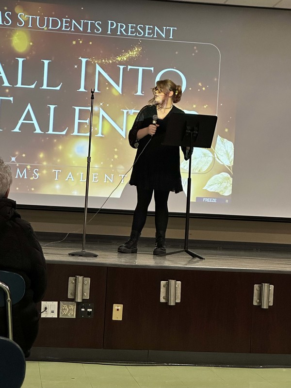 Students stand on stage at talent show