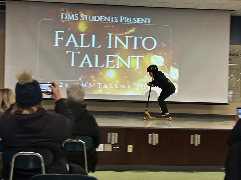 Students stand on stage at talent show