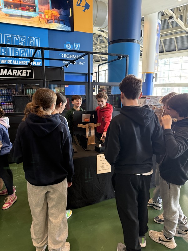 Students pose for a photo with cardboard arcade projects.