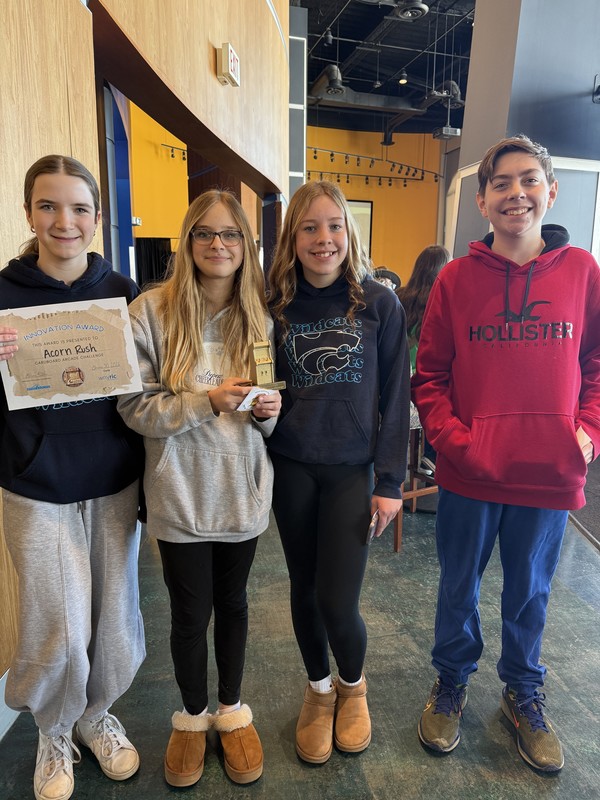 Students pose for a photo with cardboard arcade projects.
