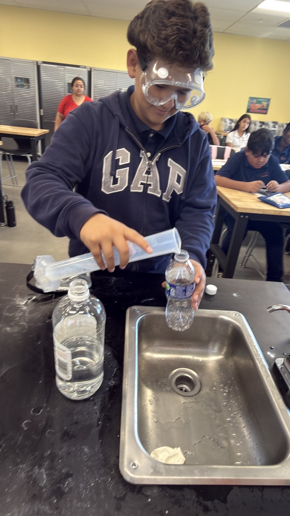 Student pouring water in water bottle.