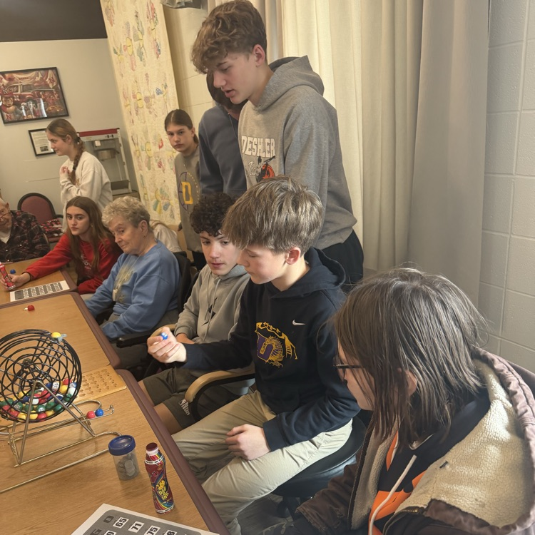 8th grade students playing cards with nursing home residents