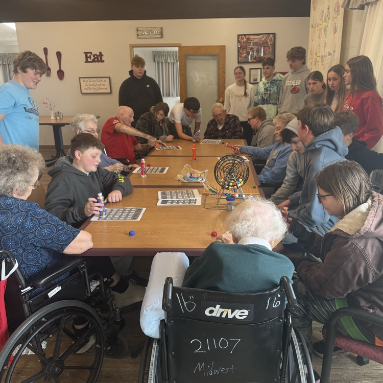 8th grade students playing cards with nursing home residents