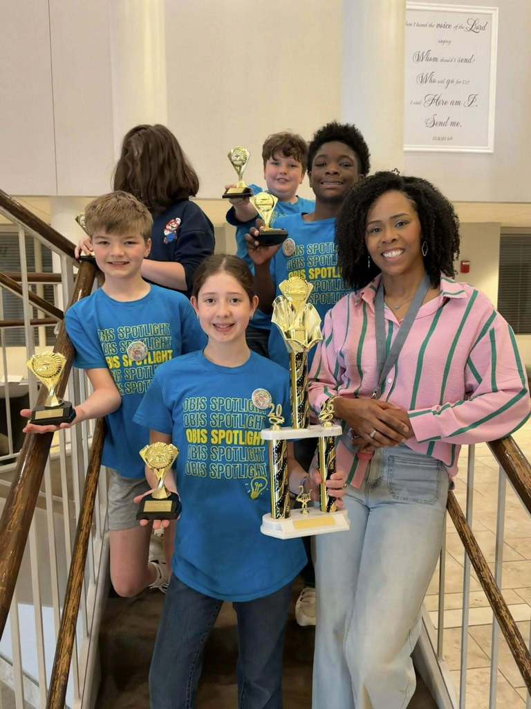 Group picture of 5 students and teacher with tropies