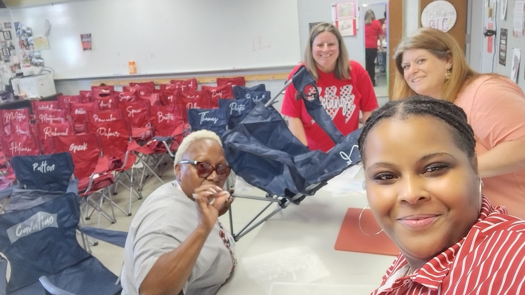 Four women personalizing camping chairs for the staff at CHMS 