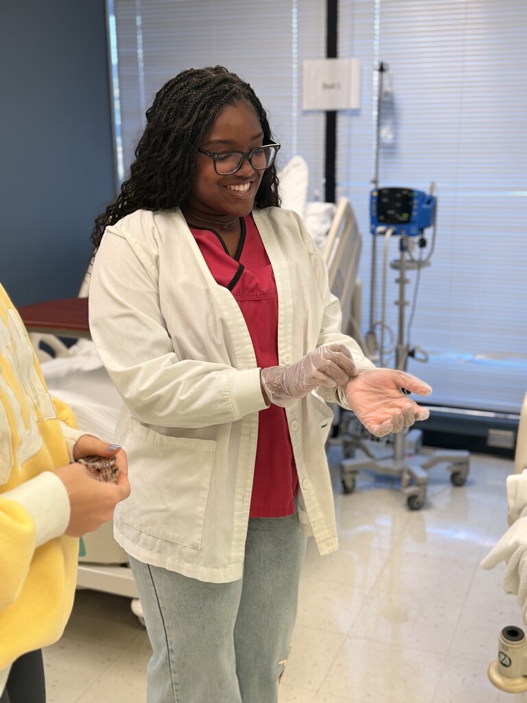student putting on med gloves