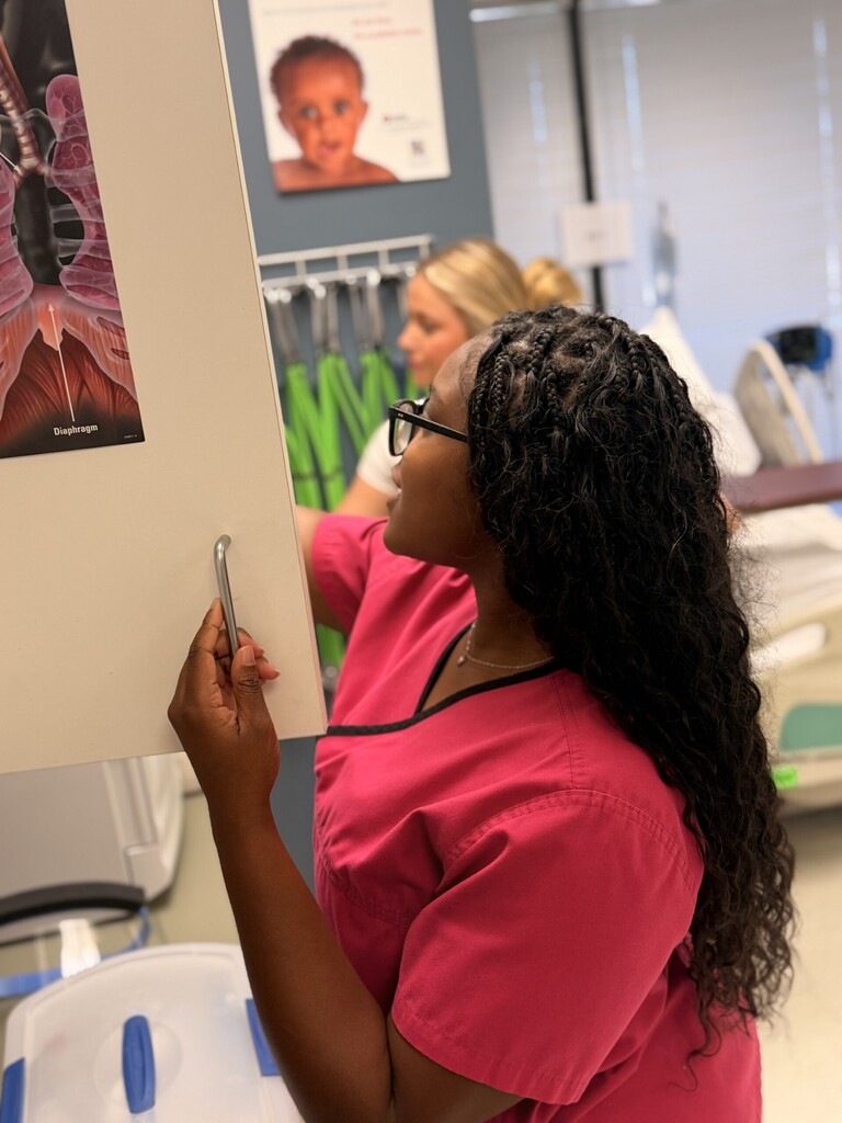 student looking through med lab cabinets for supplies