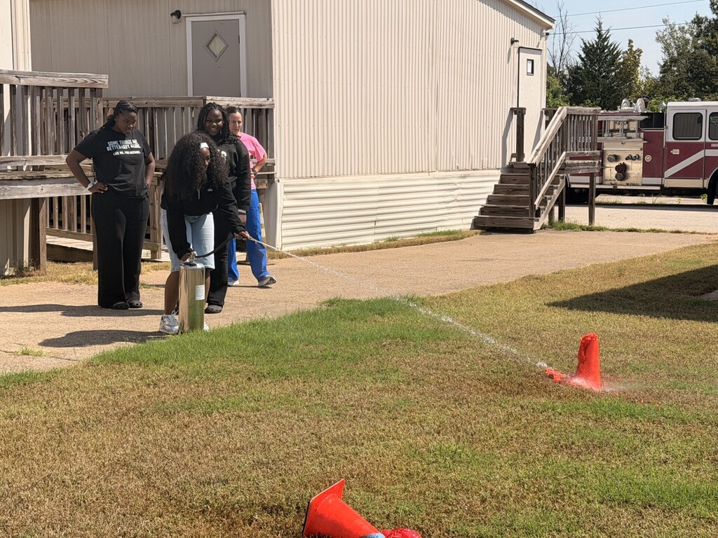 students practicing health care safety with fire extinguisher
