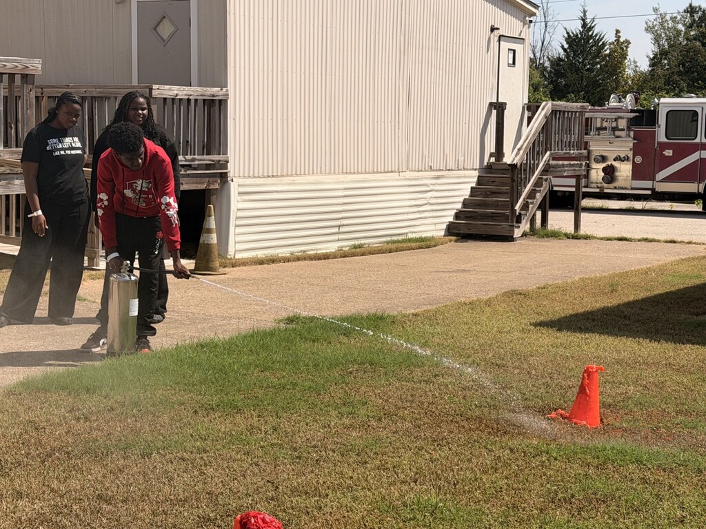 students practicing health care safety with fire extinguisher