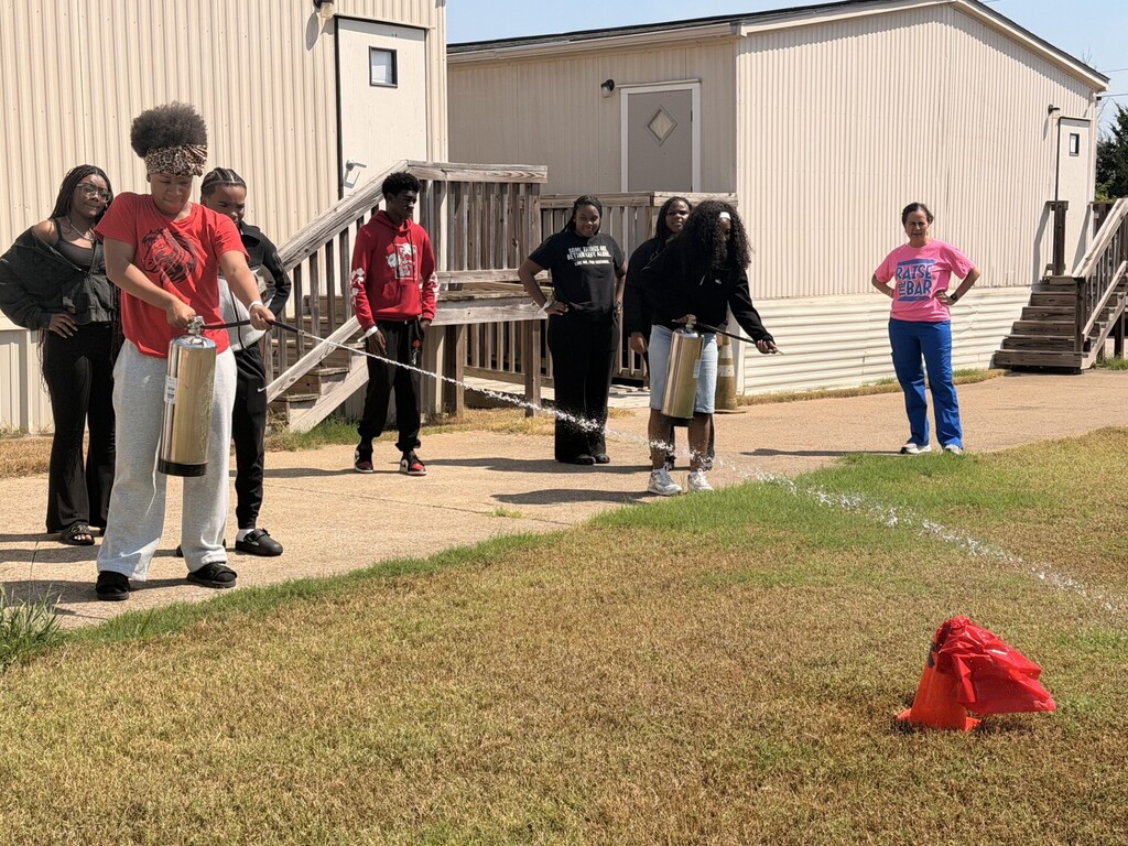 students practicing health care safety with fire extinguisher