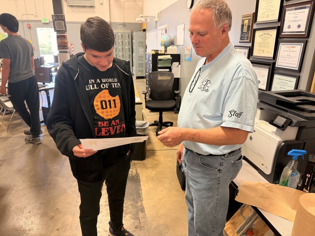 teacher giving certificate to student