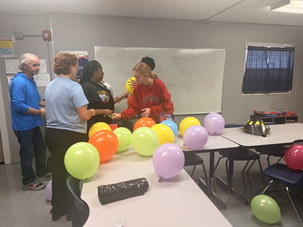 students helping blow up balloons