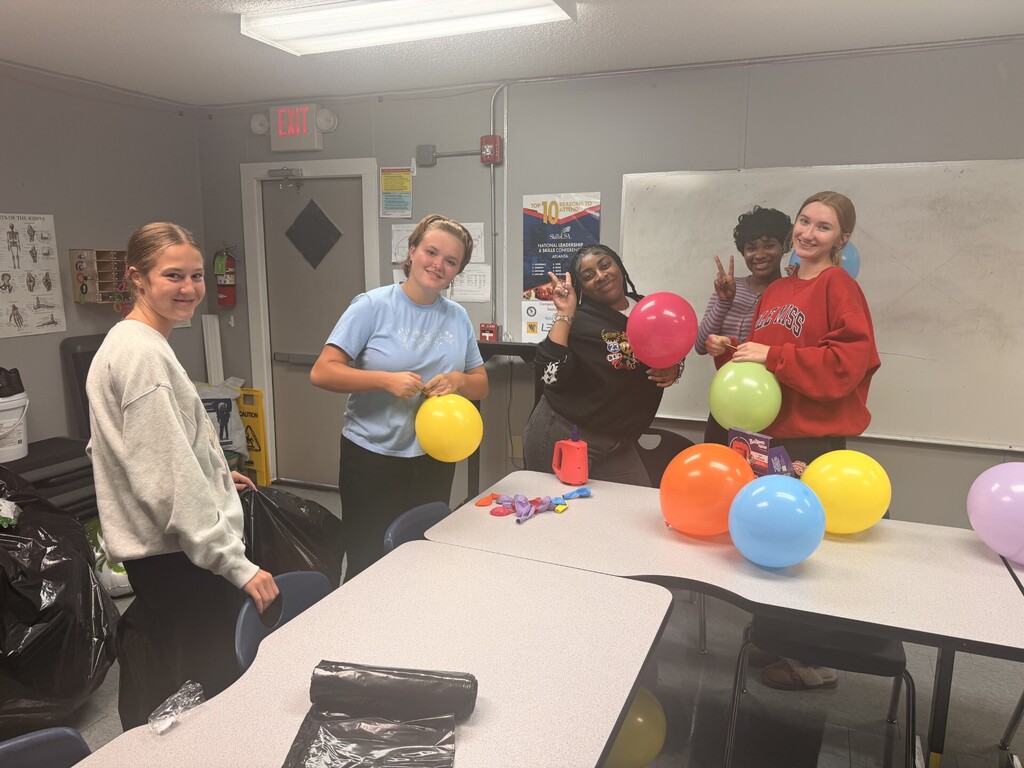 students helping blow up balloons
