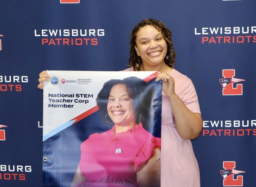 Mrs. Glasper with her National STEM Teacher Corp poster