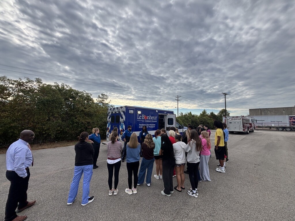 students posing in front of ambulance