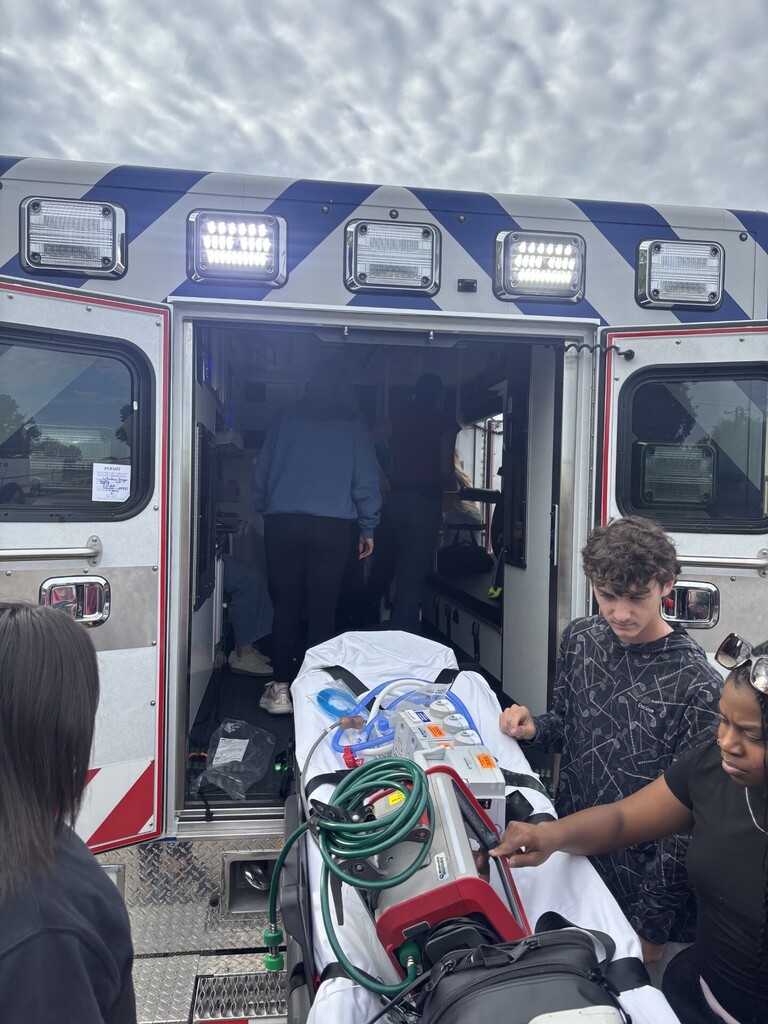 students posing in front of ambulance