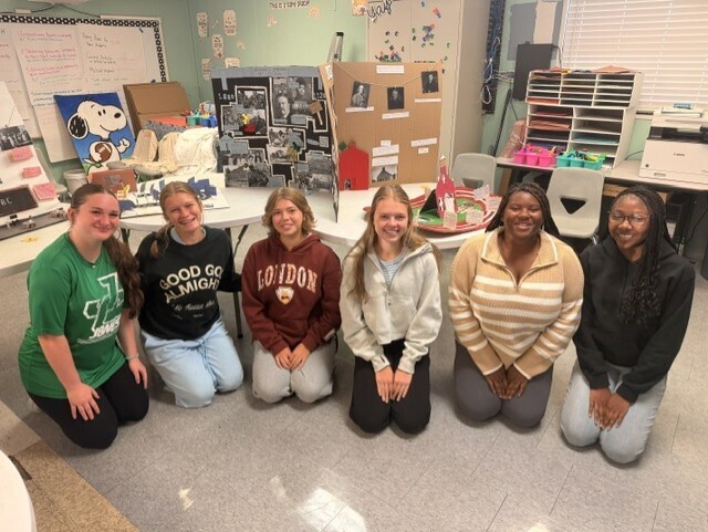 1st block ed prep students kneeling in front of their project