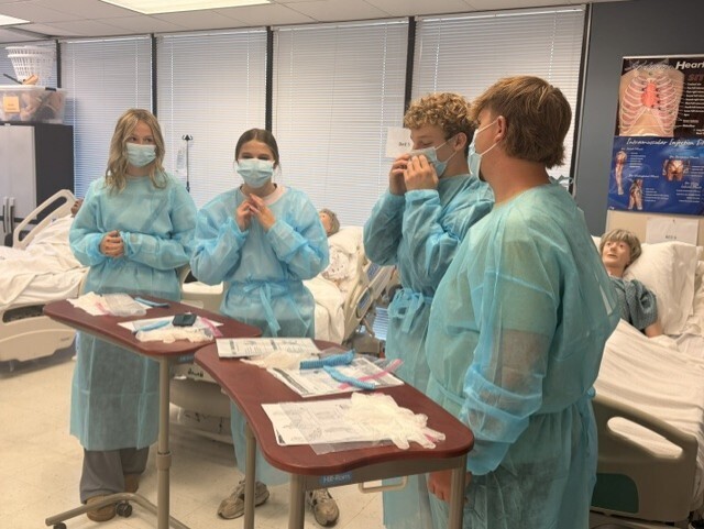 teacher and students in lab learning to put on protective 