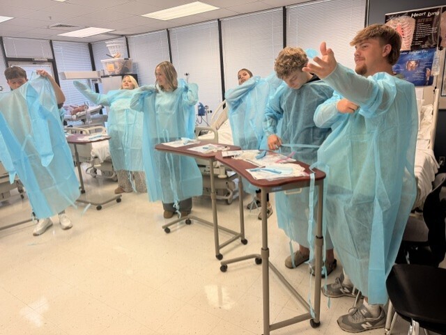 teacher and students in lab learning to put on protective 