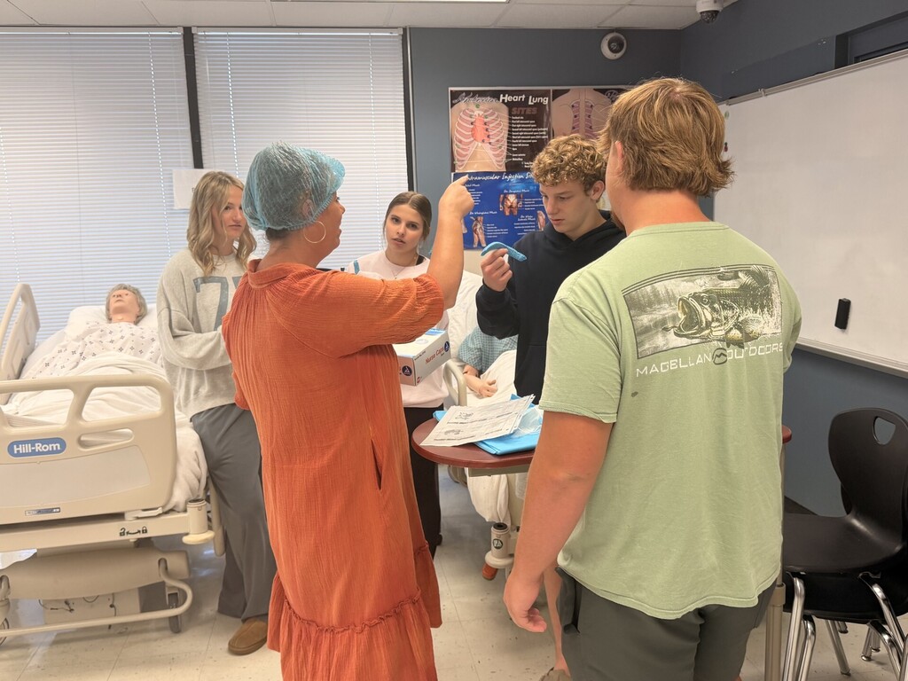 teacher and students in lab learning to put on protective 