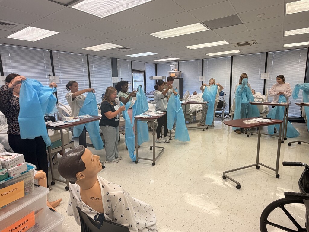 teacher and students in lab learning to put on protective 