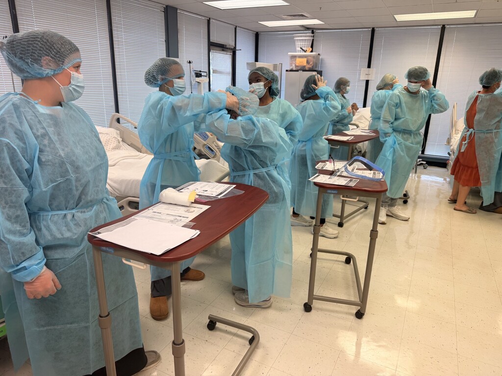 teacher and students in lab learning to put on protective 