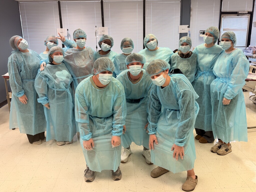 teacher and students in lab learning to put on protective 