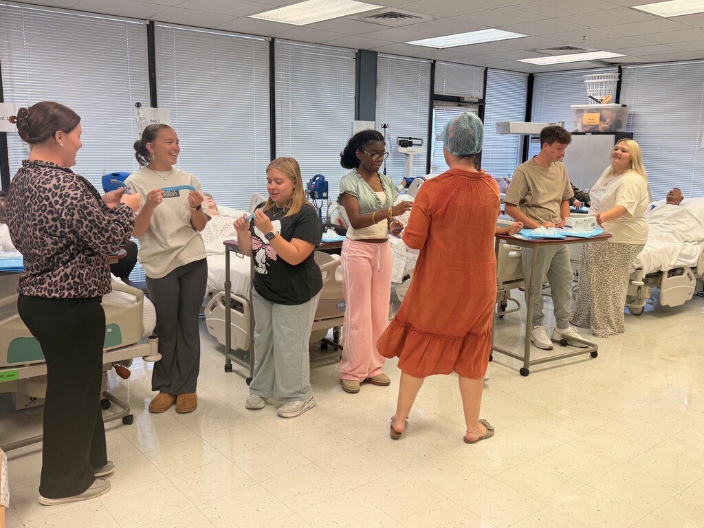 teacher and students in lab learning to put on protective 