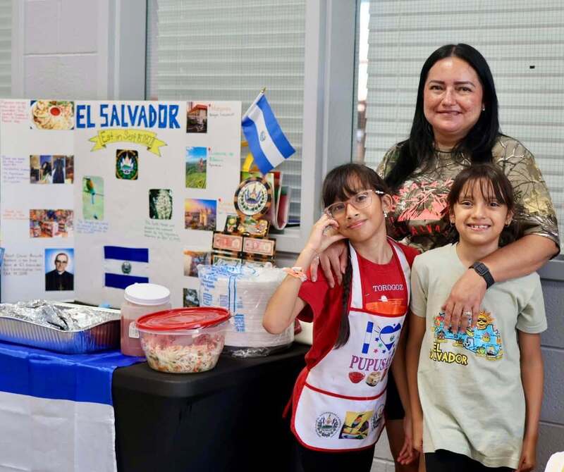 teacher with studentss in front of project