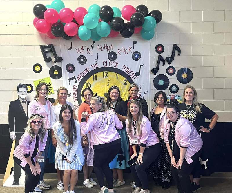 another group of teachers smiling wearing pink