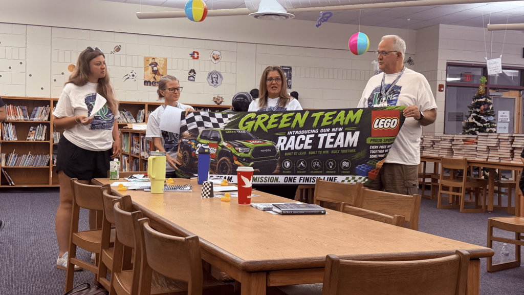 team of adults presenting and holding a banner