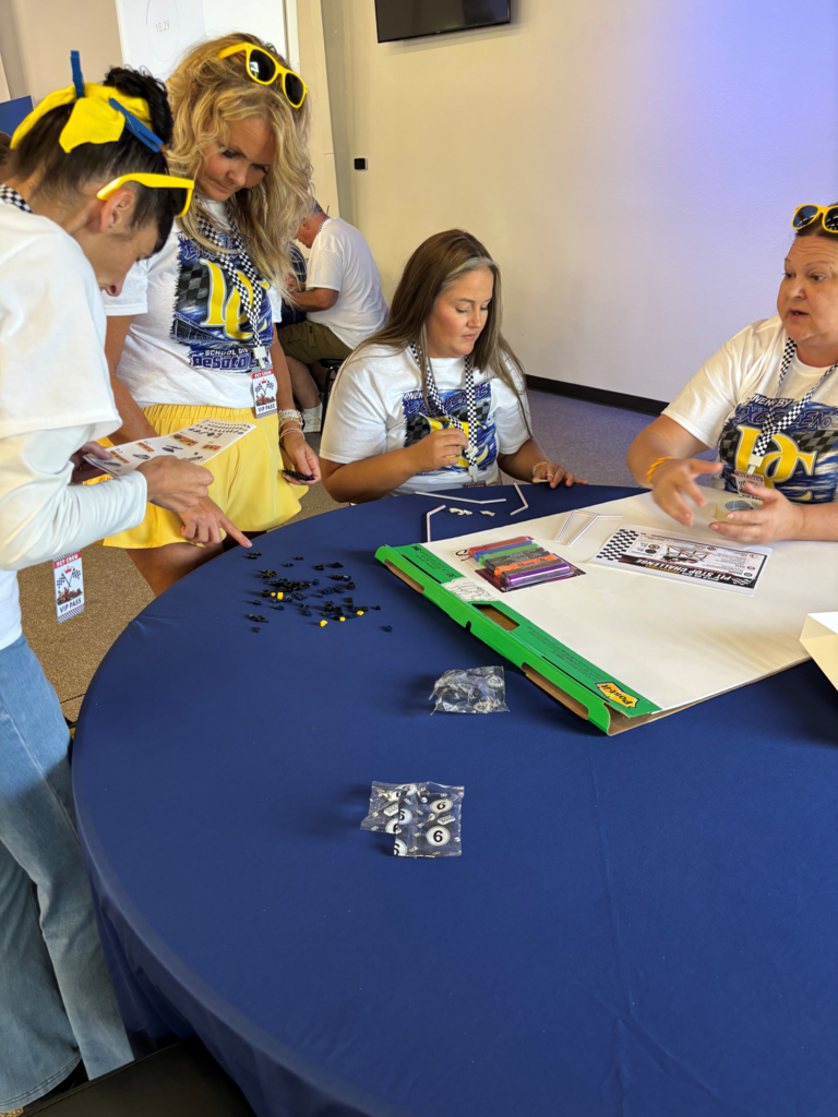 group of people around a table working on legos