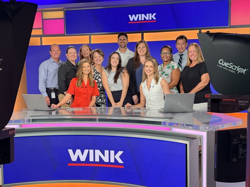 group of people posing for a pictureon the WINK new set 