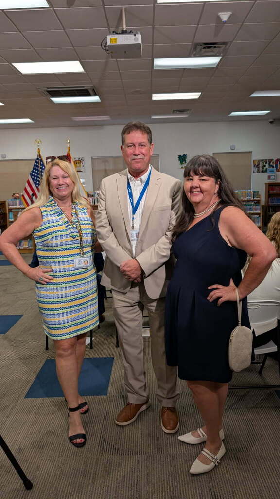 two women and a man posing for a photo