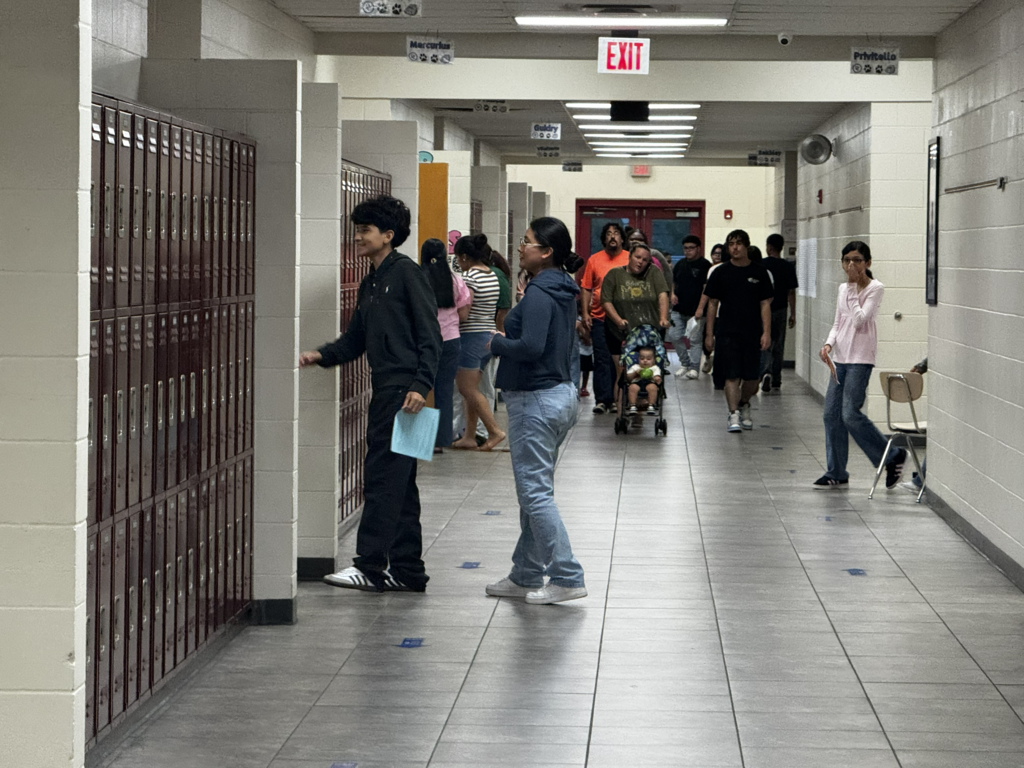 picture of middle school hallway with students and families walking to classes