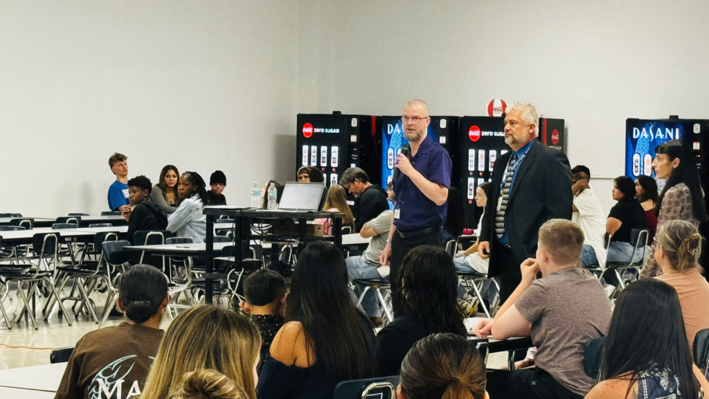 DHS administration speaking to a crowd of students in the cafeteria