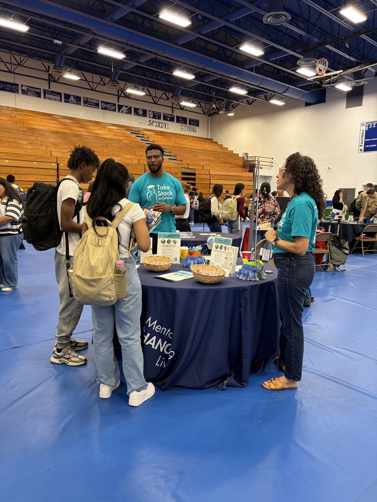 student engaging with college reps at a college day in the DHS gym