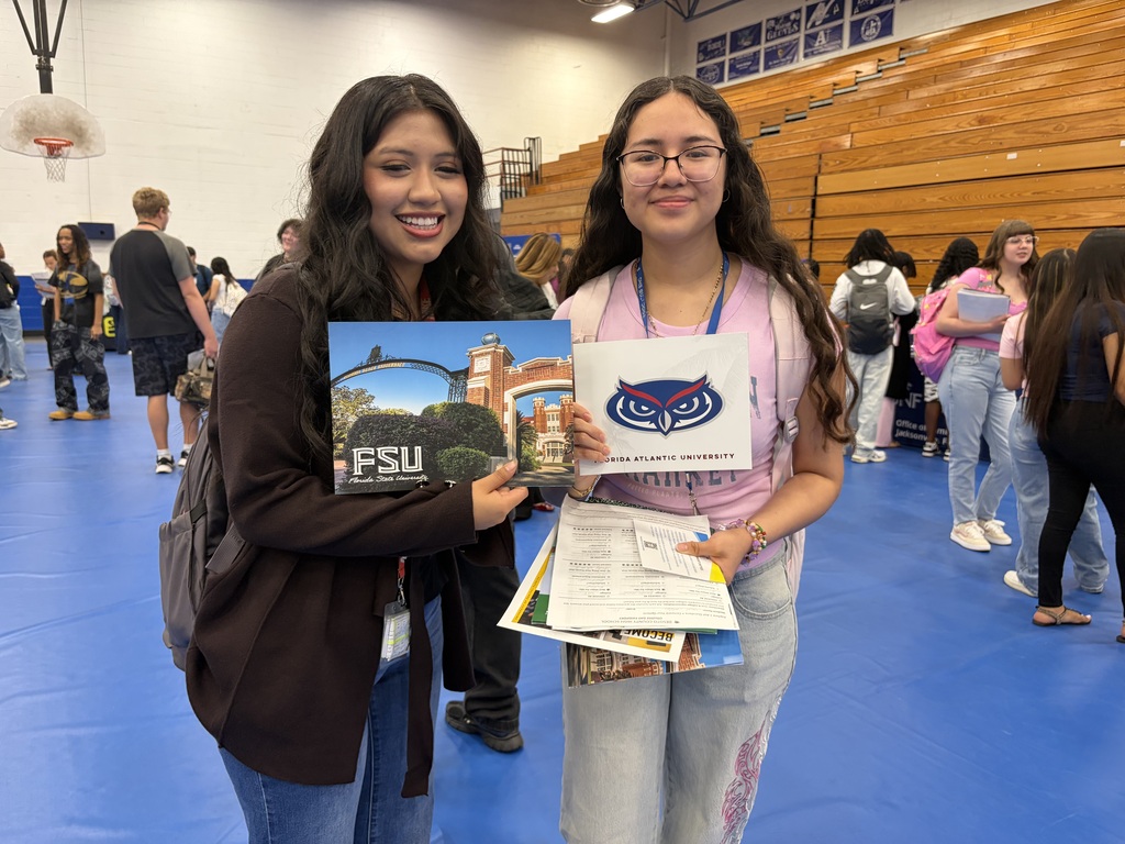 student engaging with college reps at a college day in the DHS gym