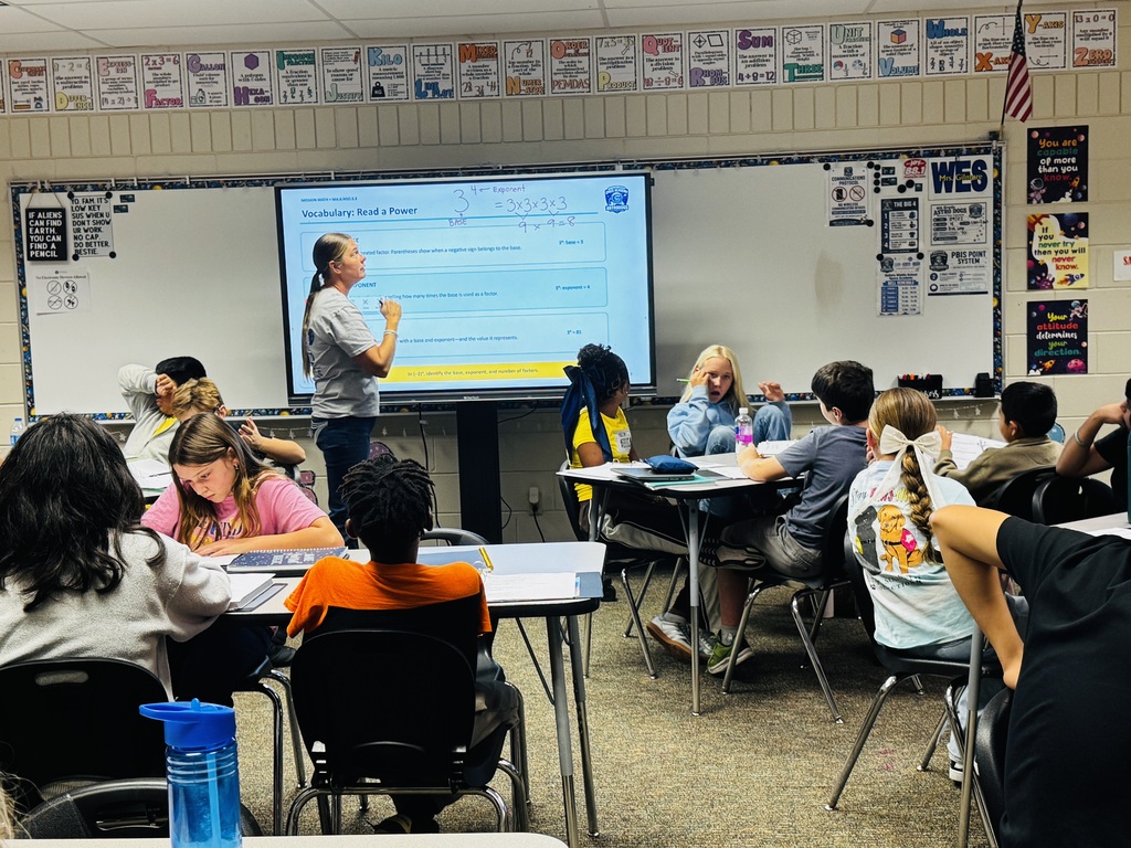 teacher giving math instruction to students