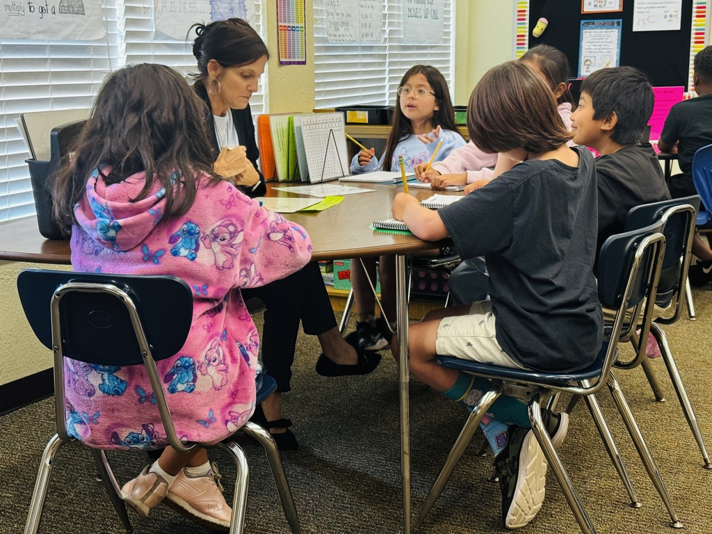 teacher at table doing small group instruction with students
