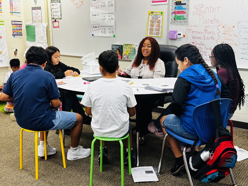 students sitting at the table working with teacher