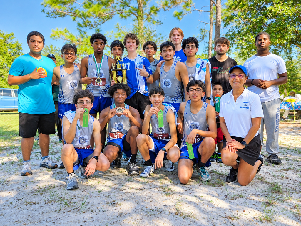 group of DHS XC runners posing for a picture with their coach
