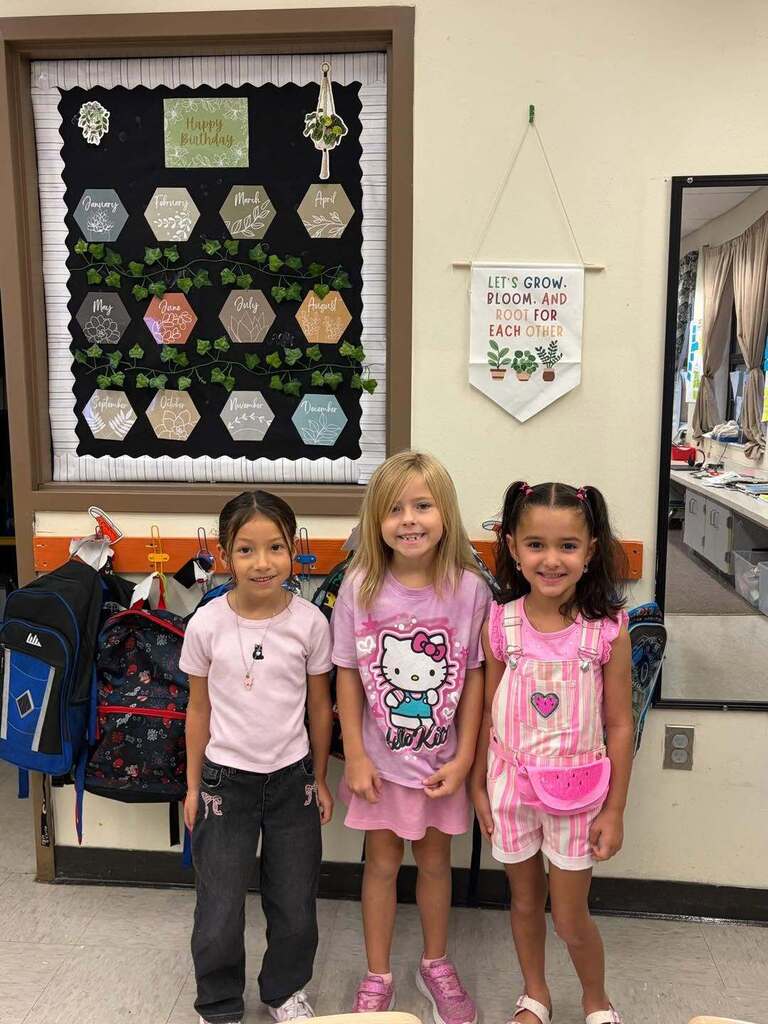 three little girls wearing pink and smiling