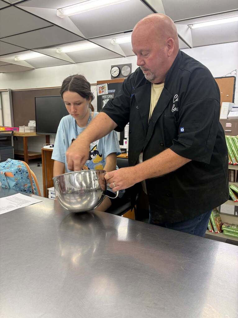 culinary teacher cooking with student