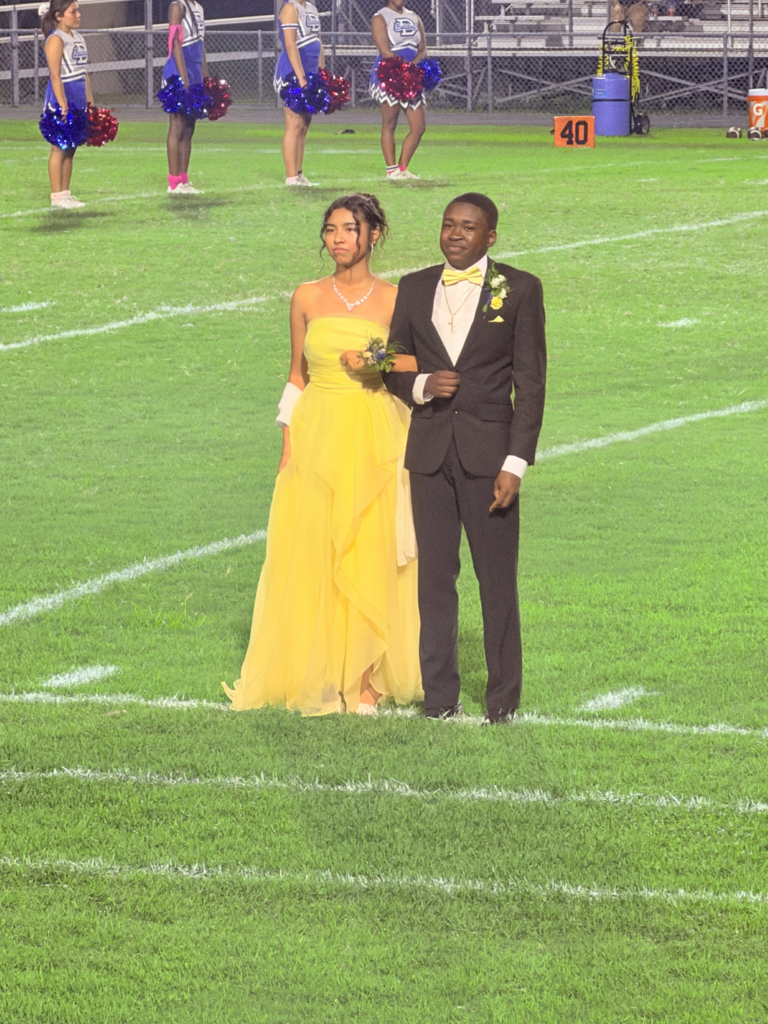 Homecoming court girl in yellow dress and guy in black suit