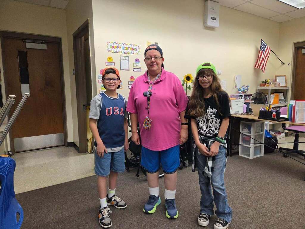 teacher and students smiling and dressed as Adam Sandler